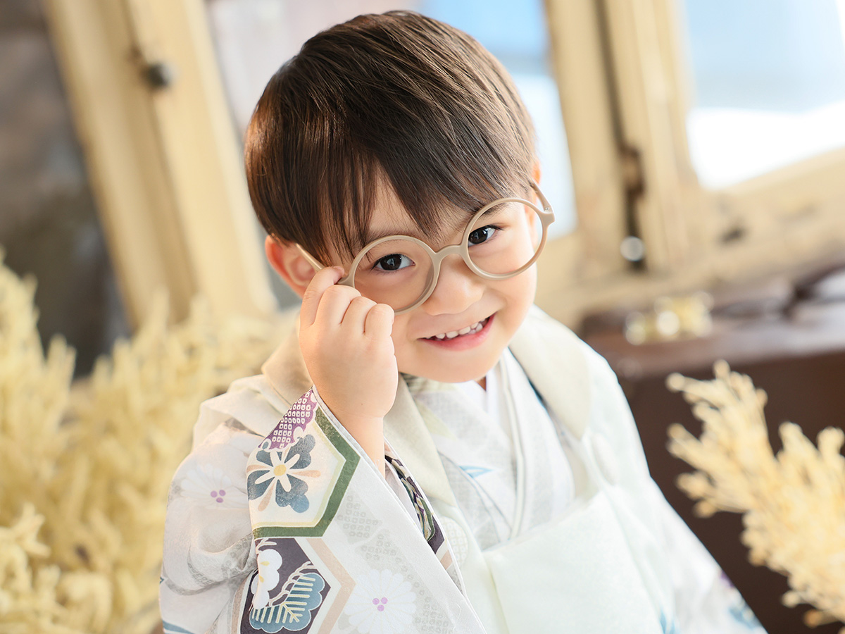 七五三の着物姿でメガネに手を添える男の子