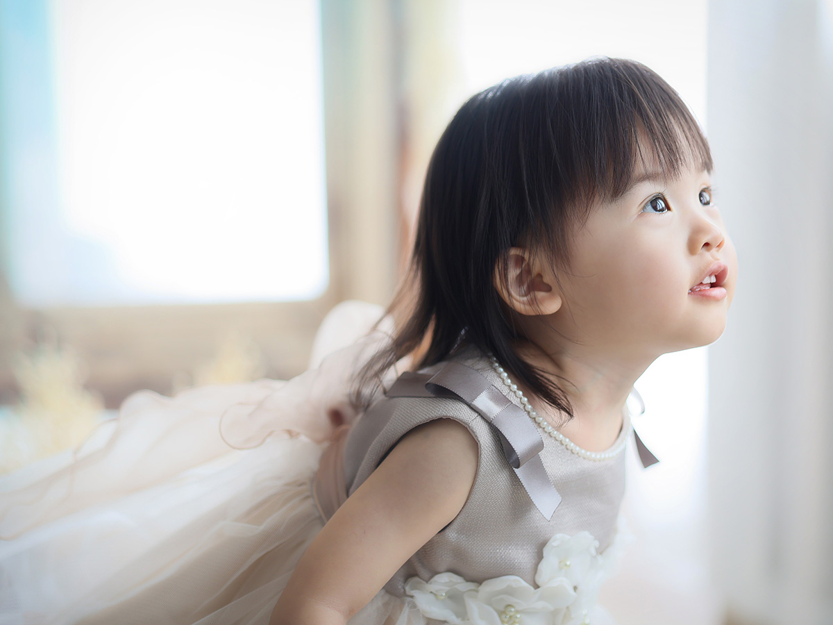 ドレス姿で上を見上げる女の子