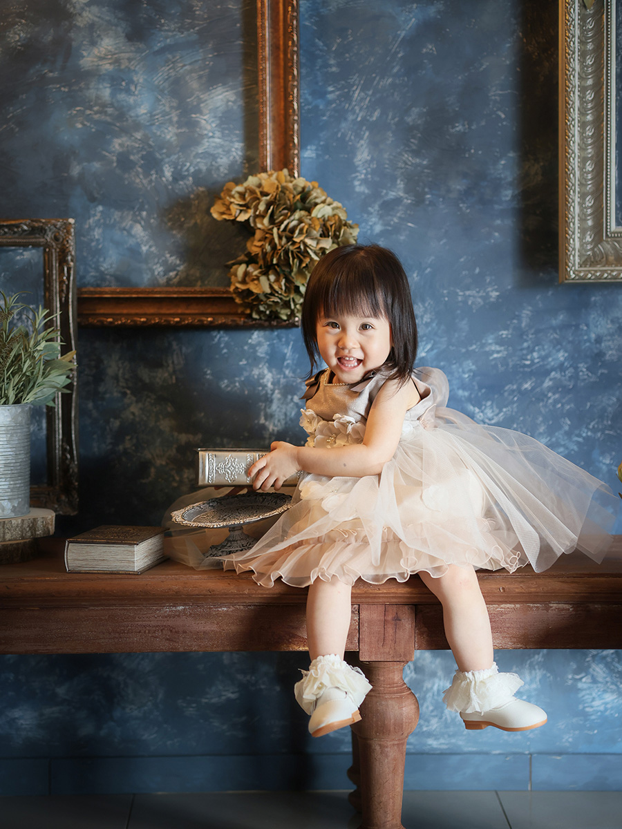 ドレス姿でテーブルに座って笑う女の子
